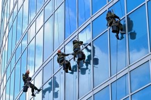 Industrial climbers are washing glass on the facade of a skyscrape